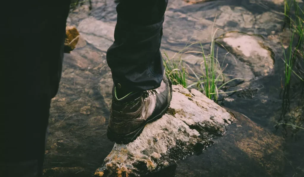 What Shoes Should You Wear in Bali? Sandals, Sneakers or Hiking Boots? 43 Water-resistant hiking boots for Bali standing on wet rocks, recommended footwear for waterfalls and rainy season hiking.