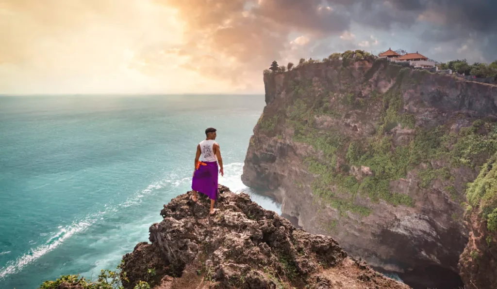 Slow Tourism in Bali: Why More Travelers Are Skipping the Checklist and Staying Put 41 Slow Tourism in Bali traveler taking time to enjoy the dramatic cliffs and ocean views in Uluwatu instead of rushing between attractions.