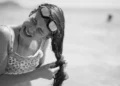Woman struggling with tangled sticky hair after swimming in the ocean without rinsing off salt water.