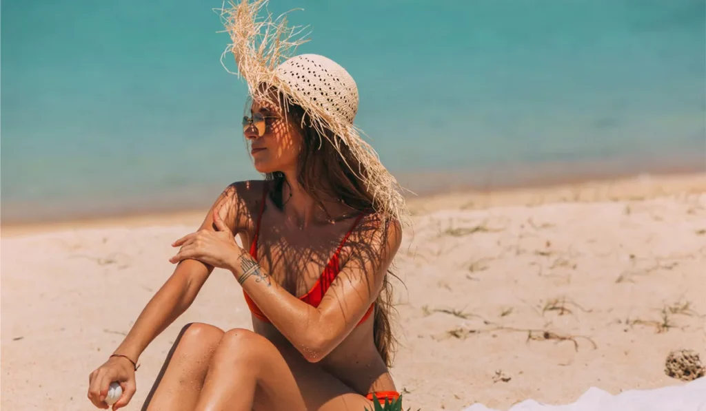 Can You Get Sunburned on a Cloudy Day? Doctors Say Yes, and Bali's Overcast Days Are No Exception 3 Can You Get Sunburned on a Cloudy Day? A photo of a female tourist sunbathing on a beach in Bali, wearing a straw hat.