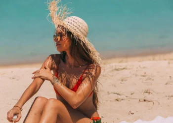 Can You Get Sunburned on a Cloudy Day? Doctors Say Yes, and Bali's Overcast Days Are No Exception 39 Can You Get Sunburned on a Cloudy Day? A photo of a female tourist sunbathing on a beach in Bali, wearing a straw hat.