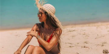Can You Get Sunburned on a Cloudy Day? Doctors Say Yes, and Bali's Overcast Days Are No Exception 2 Can You Get Sunburned on a Cloudy Day? A photo of a female tourist sunbathing on a beach in Bali, wearing a straw hat.