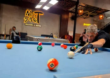 A photo of an American man named Larry playing billiards at Next Shoot Bali (Hey Bali News).