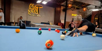 A photo of an American man named Larry playing billiards at Next Shoot Bali (Hey Bali News).
