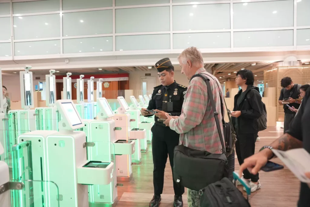 Indonesia Wants Better Tourists, Not Just More Tourists 38 An Indonesian immigration officer assists an international traveller at an automated immigration gate, highlighting Indonesia's modern border control and digital immigration system.