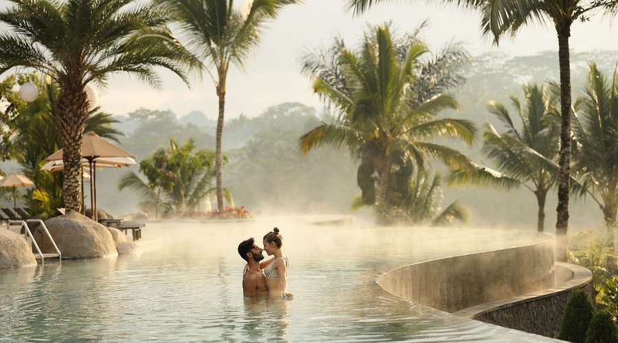 A photo of tourists looking romantic at a hotel pool in Ubud. Happy after arriving at Bali airport on their way to Ubud.