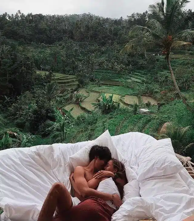 Bali Survival Guide - Romantic photo of a couple kissing in a villa with a view of trees typical of ubud bali