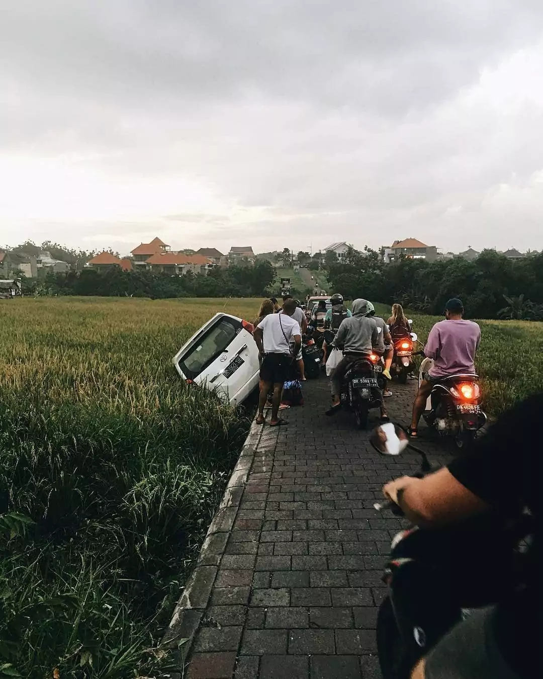photo of car flipped into rice field due to shortcut