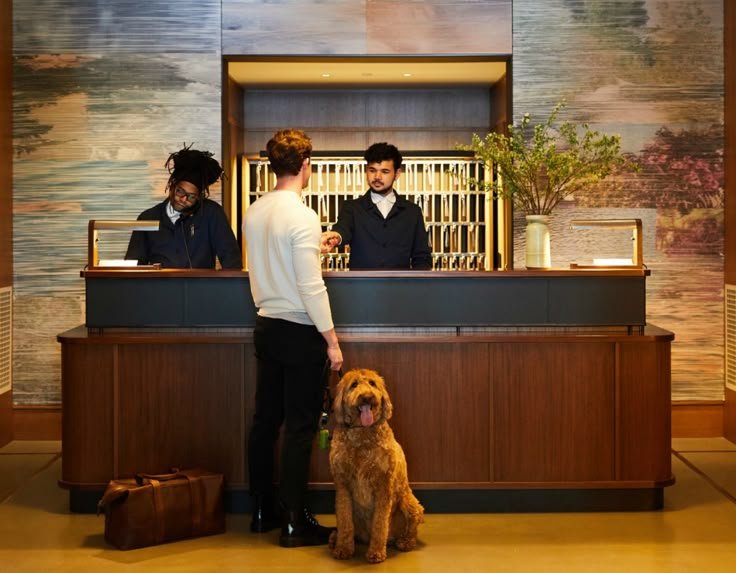 photo of a man checking in in front of the hotel receptionist with 1 piece of luggage and a dog. - luggage storage Bali to Gili 