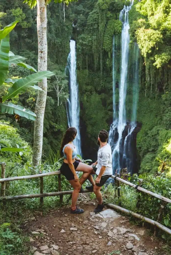 A couple of tourists are posing at a waterfall in northern Bali.