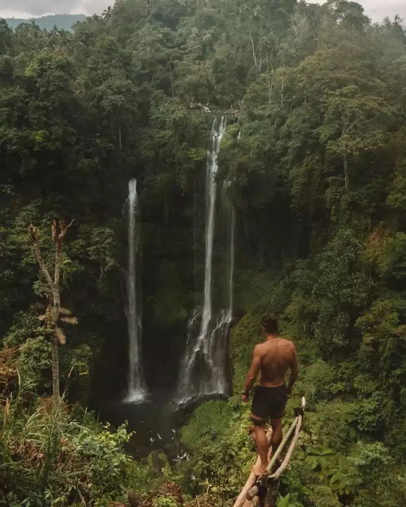 A male tourist from Bali poses with a view of the forest in northern Bali.
