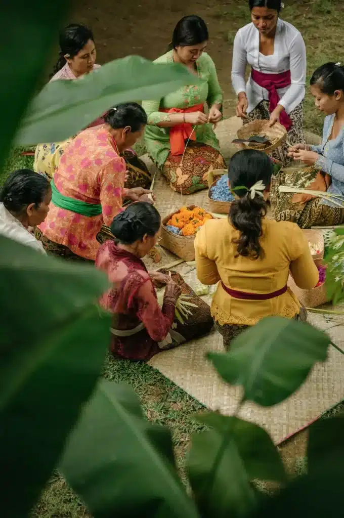 Balinese women gathering and making canang sari - Om Swastiastu meaning