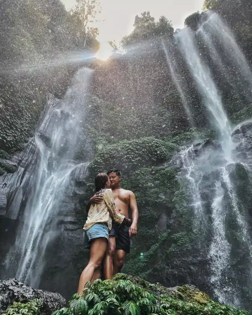 The couple is posing at Sekumpul Waterfall in Bali.