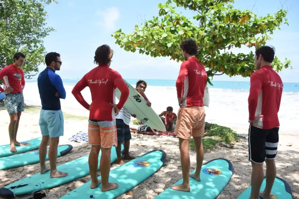 An instructor is giving an explanation to five European tourists on Sanur Beach, Bali.
