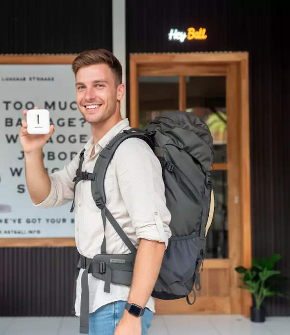 A photo of an Australian male tourist receiving a free adapter from Hey Bali. This photo was taken in front of the Hey Bali office. The man looks happy to receive the free adapter.     