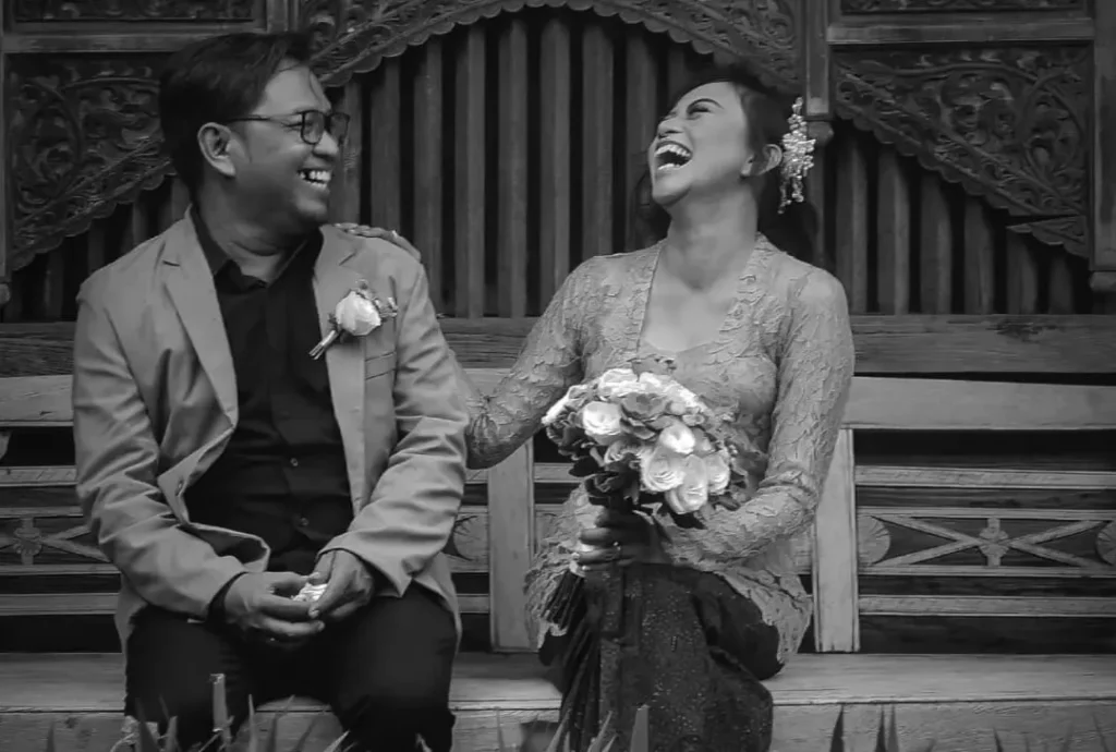 A couple laughing during a pre-wedding photo shoot in Bali because of a mistake they made.