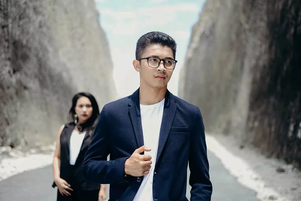photo of a couple taking a photo at the entrance to Pandawa Beach with cliffs in the background on the right and left