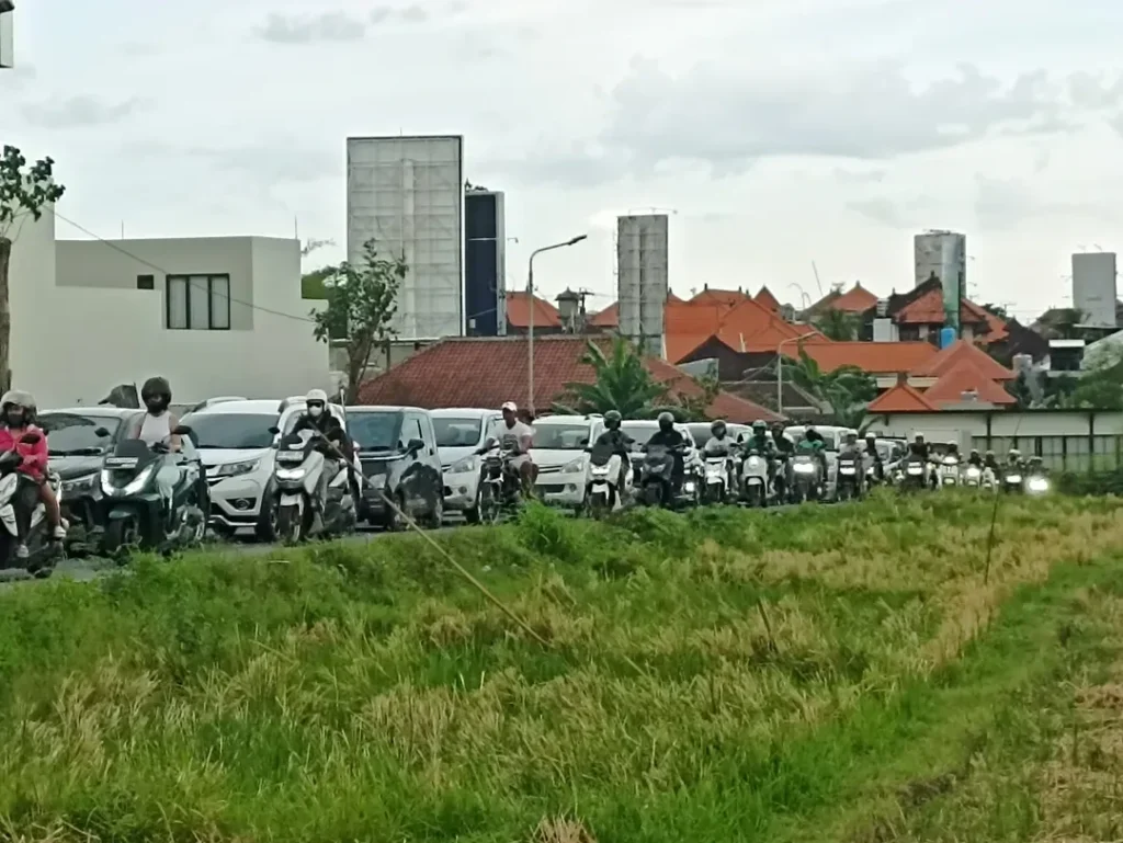 Heavy traffic on the road in Canggu, showing cars and motorbikes stuck in congestion near Kerobokan area.