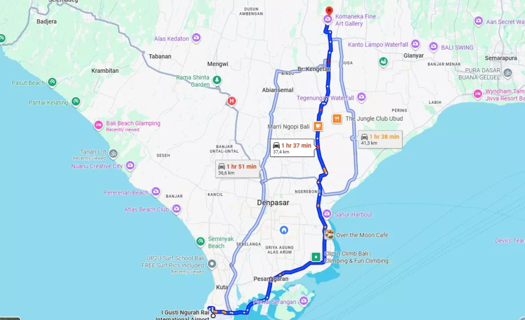 Bali Airport to Ubud Transfer route map showing a 1 hr 37 min (37.4 km) journey from I Gusti Ngurah Rai International Airport in the south of Bali (near Kuta/Seminyak) to the Komaneka Fine Art Gallery area in Ubud, passing near Denpasar. An alternative route is also shown at 1 hr 51 min (35.6 km).