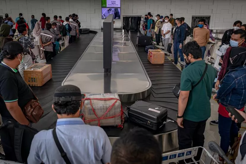 Airplane passengers are waiting for their luggage at Bali airport